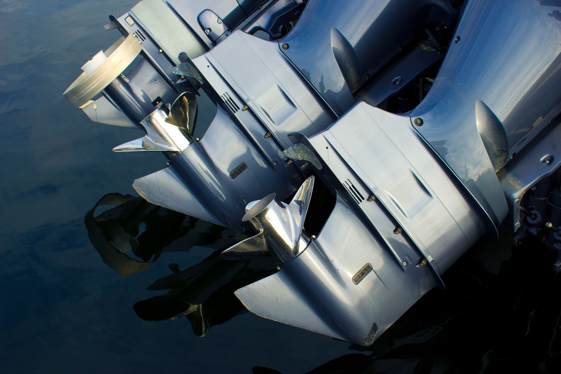 A row of outboard motors are sitting in the water