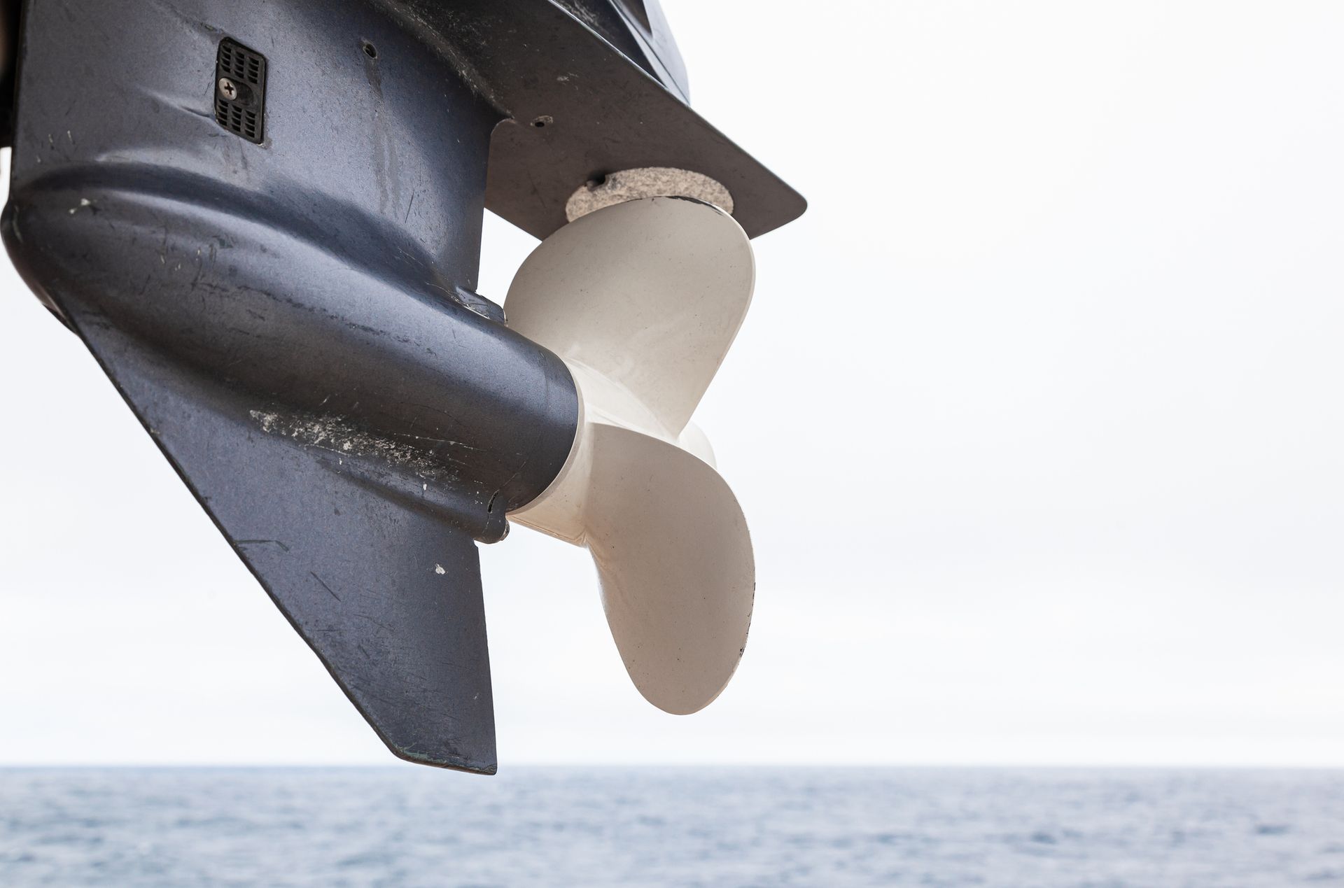 A close up of a boat propeller in the ocean.