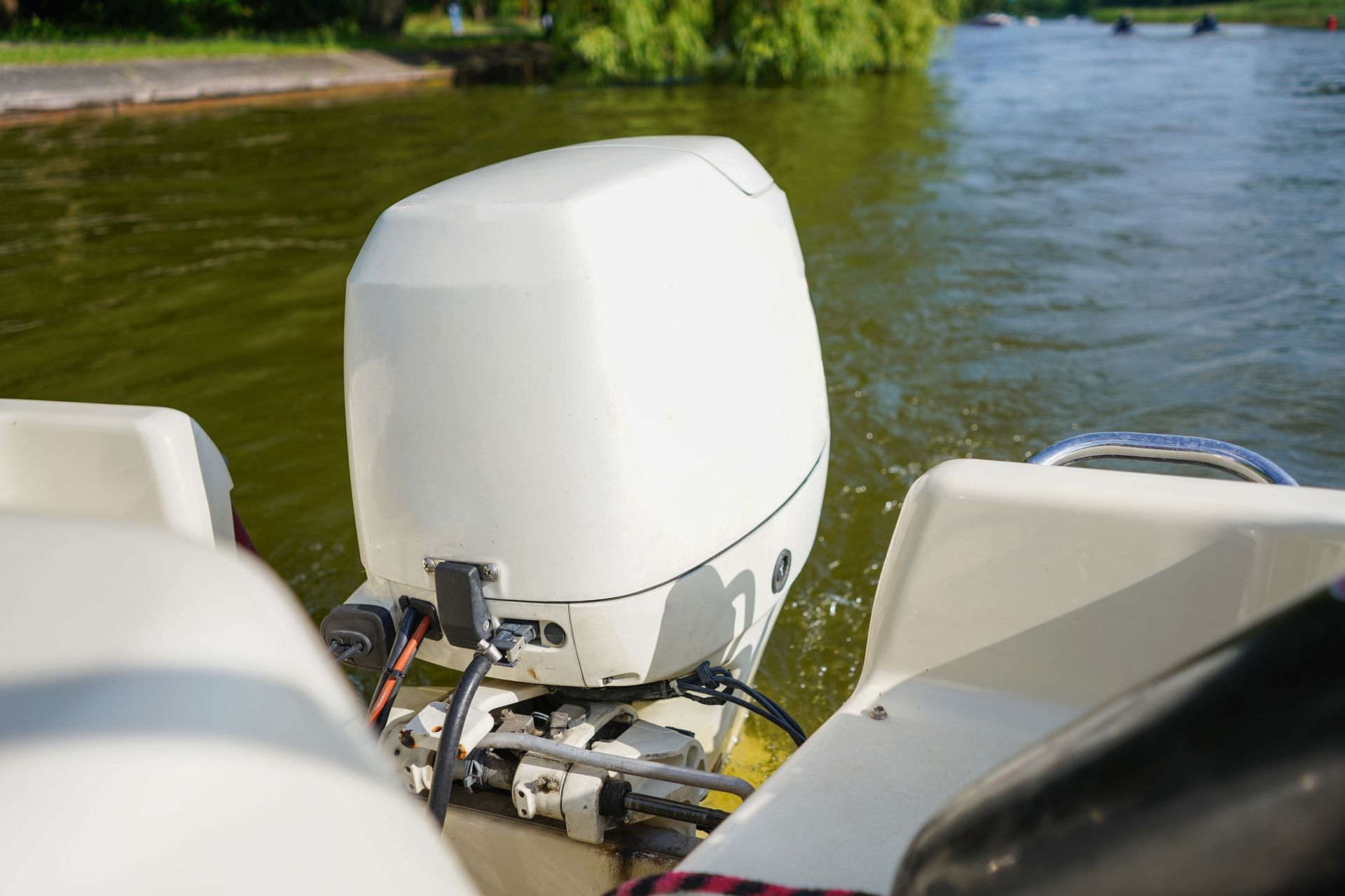 A white outboard motor is sitting on the side of a boat in the water.