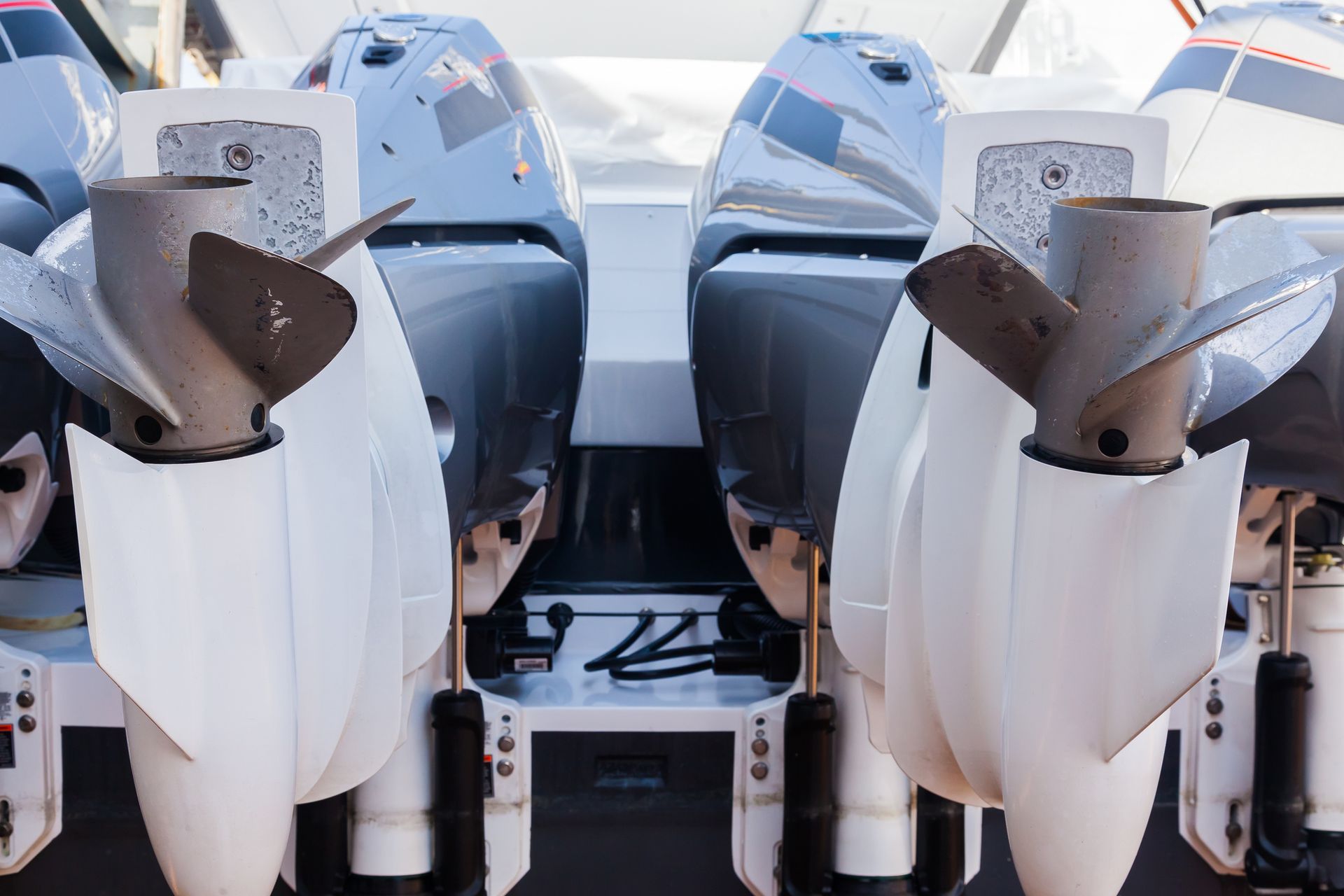 A row of four outboard motors on a boat.