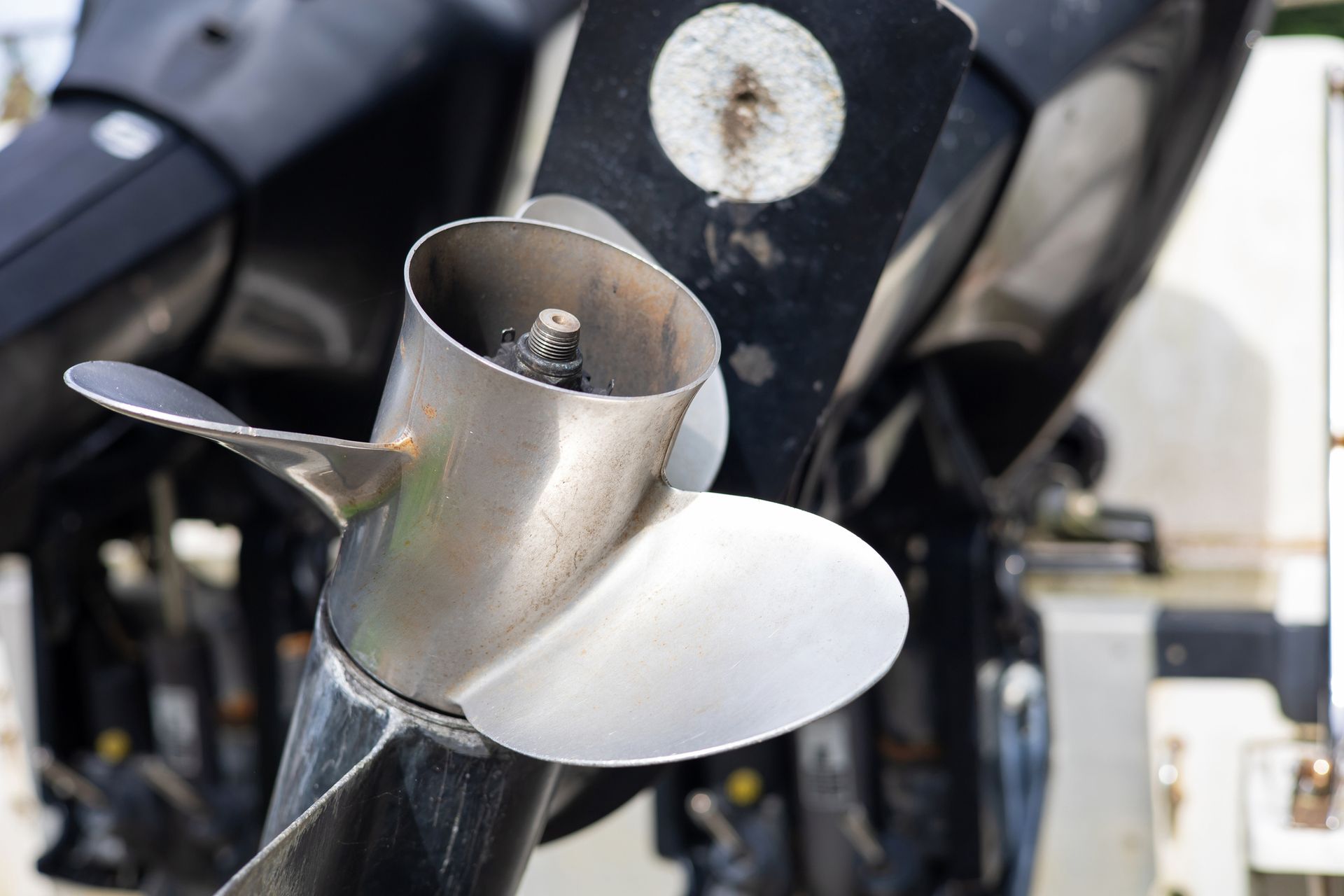 A close up of a stainless steel propeller on a boat.