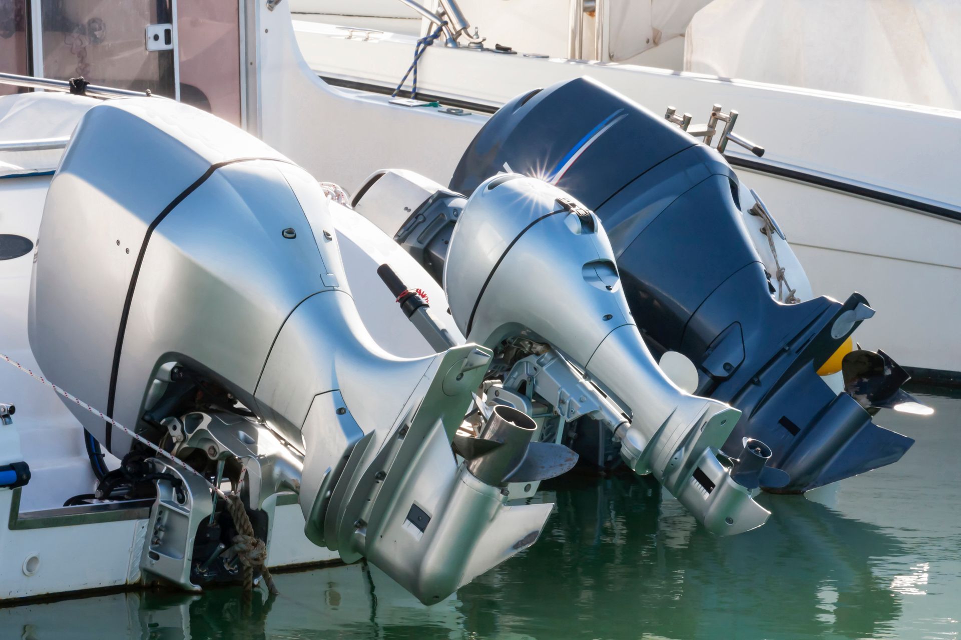 Two outboard motors are sitting next to each other in the water.