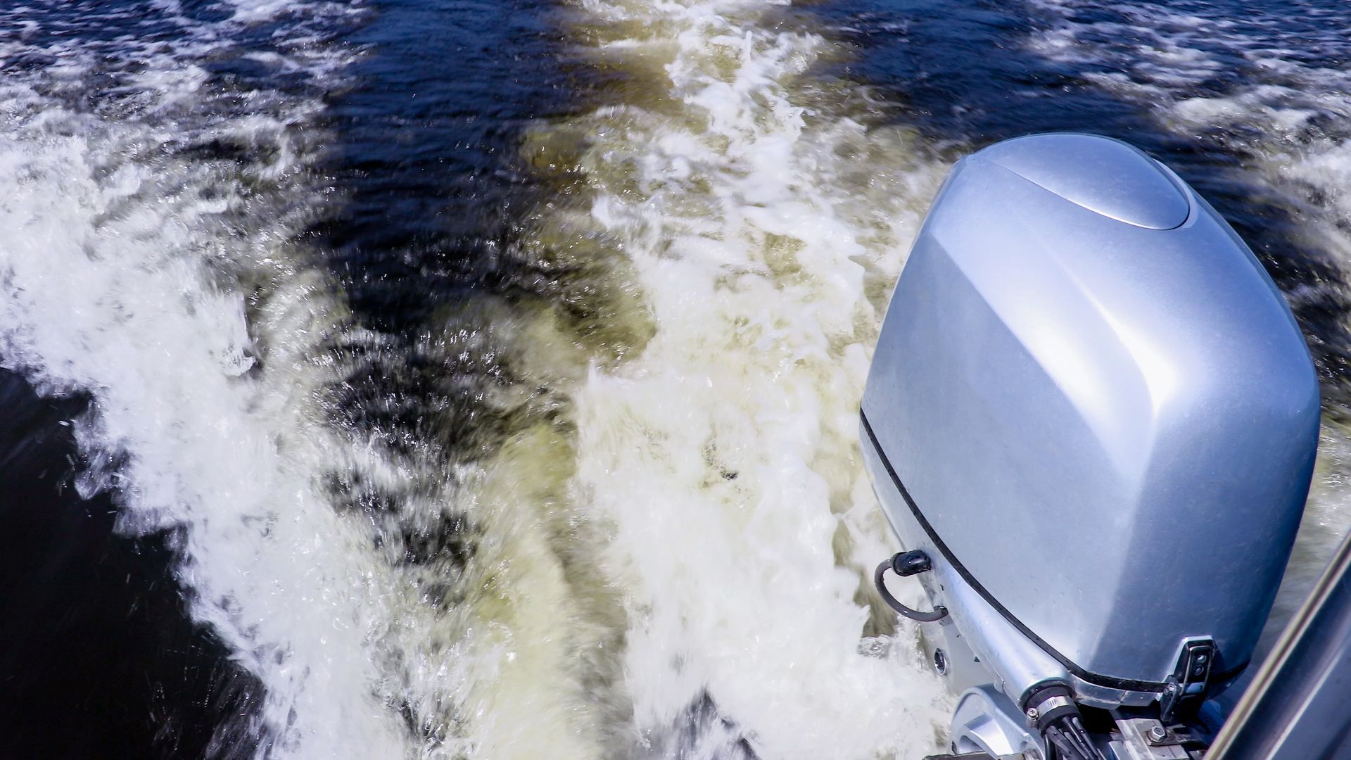 A boat with a motor is floating on top of a body of water.