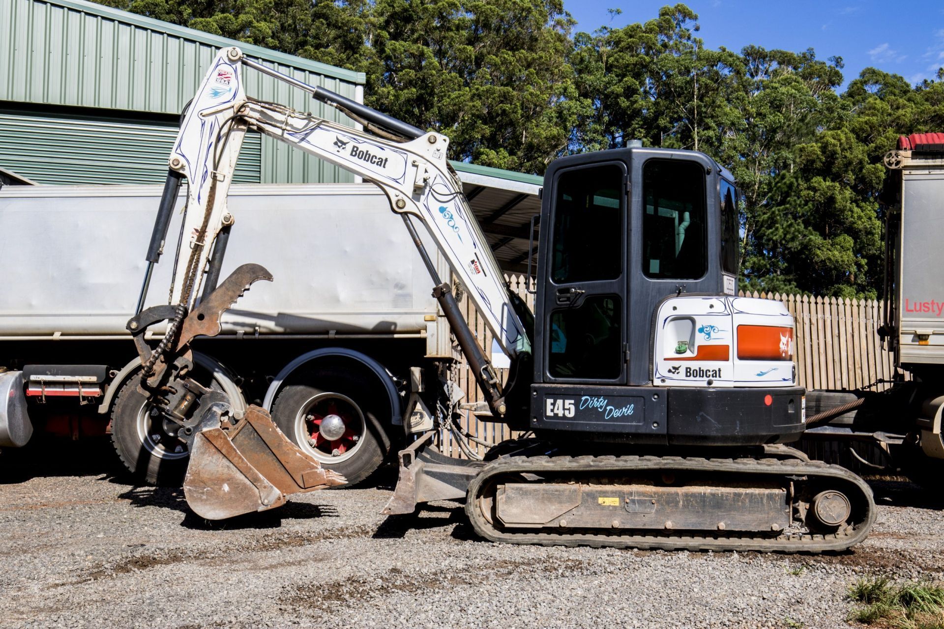 Excavator Loading Dirt Into a White Dump Truck — Evans Earthmoving Contractors In Mareeba, QLD