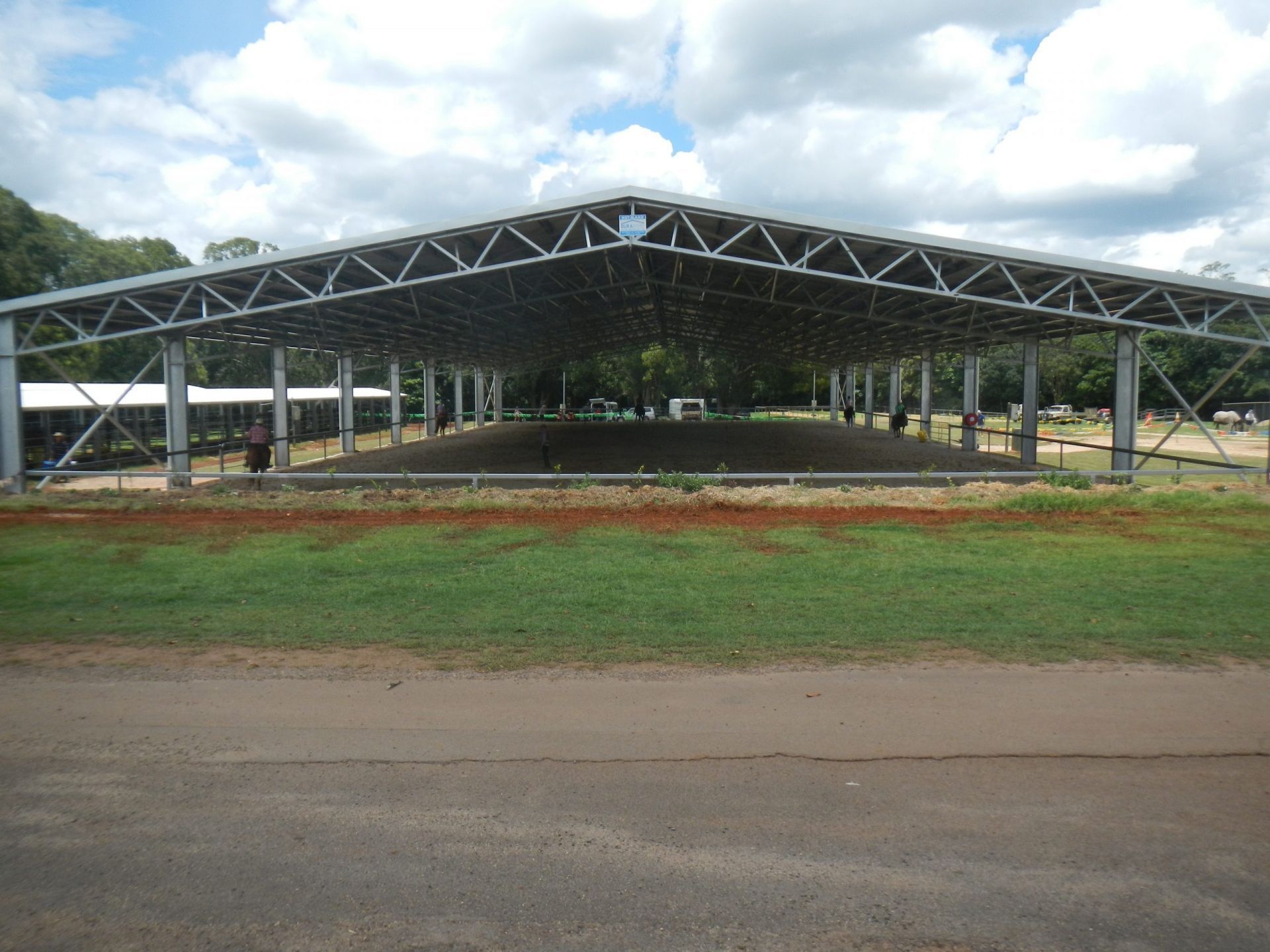 Large Steel-Framed Open-Air Structure with A Dirt Floor, Located on A Grassy Area Next to A Road — Evans Earthmoving Contractors In Malanda, QLD