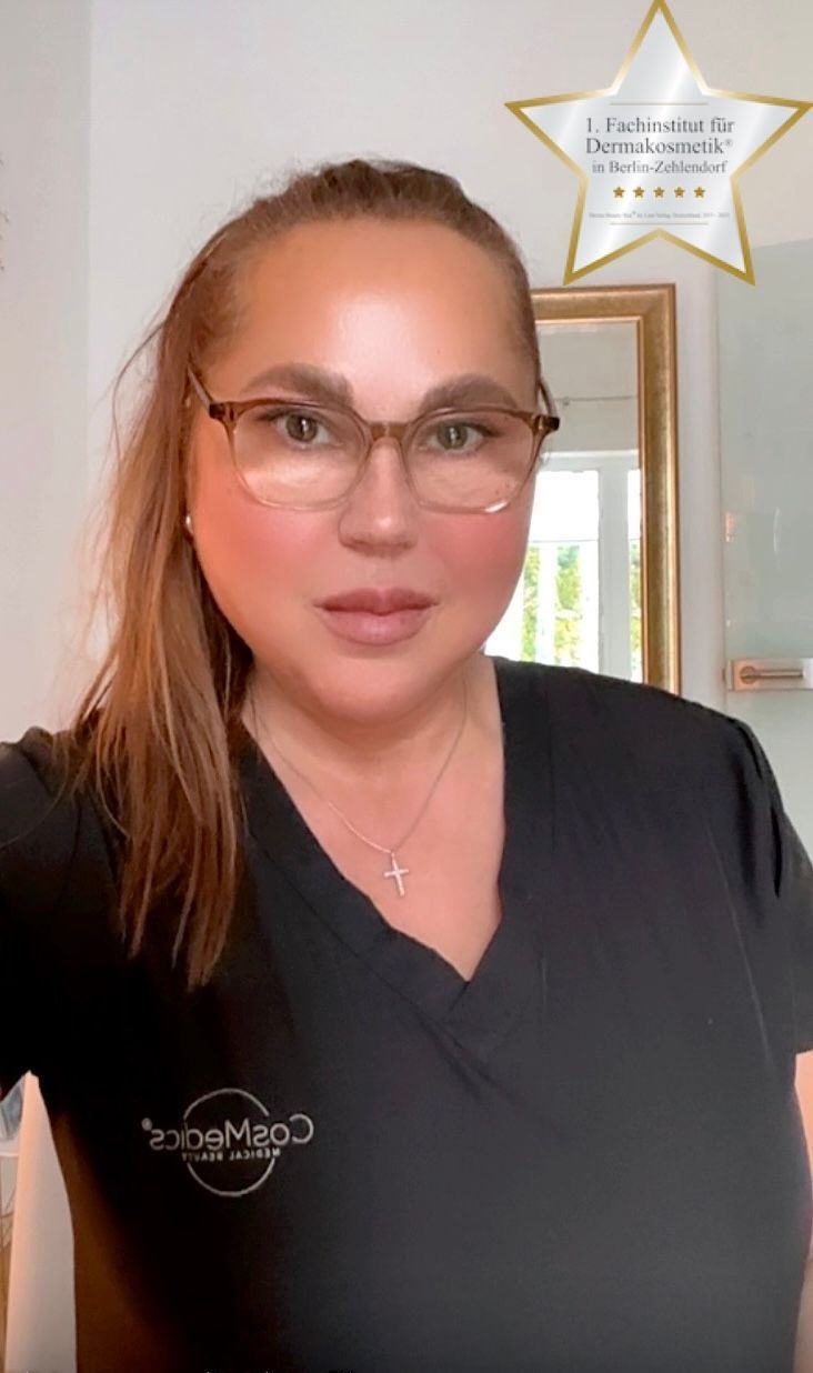 Eine Frau trägt ein weißes Hemd und eine Halskette mit einem Kreuz.