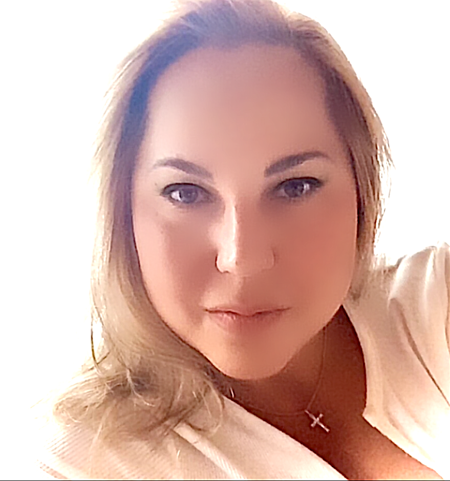 Eine Frau trägt ein weißes Hemd und eine Halskette mit einem Kreuz.