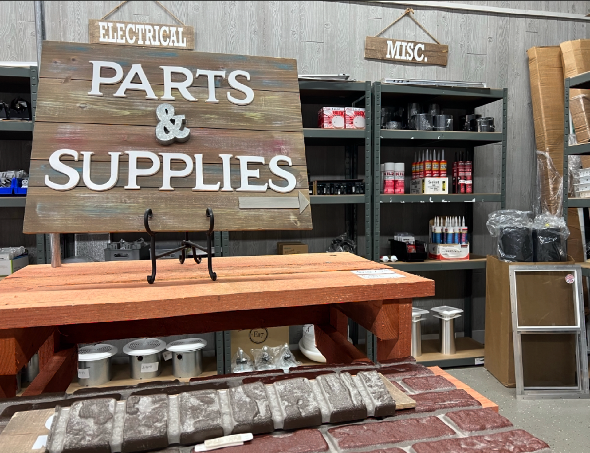 A wooden sign that says `` parts & supplies '' is sitting on top of a wooden table.