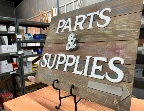 A wooden sign that says parts and supplies on it