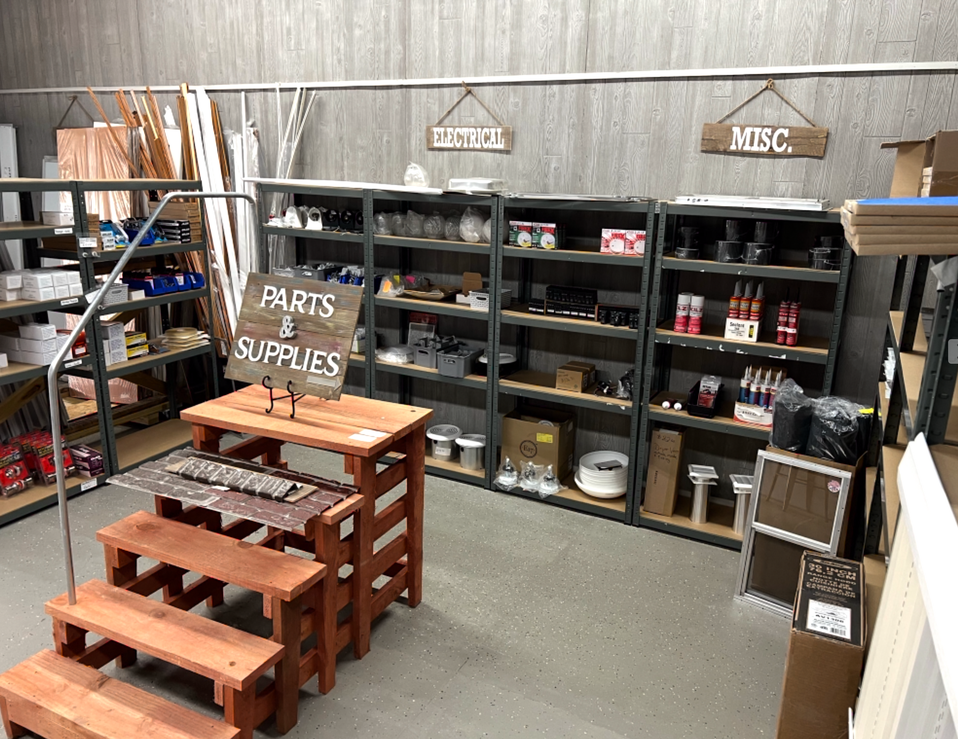 A warehouse filled with lots of shelves and boxes and a sign that says parts and supplies.
