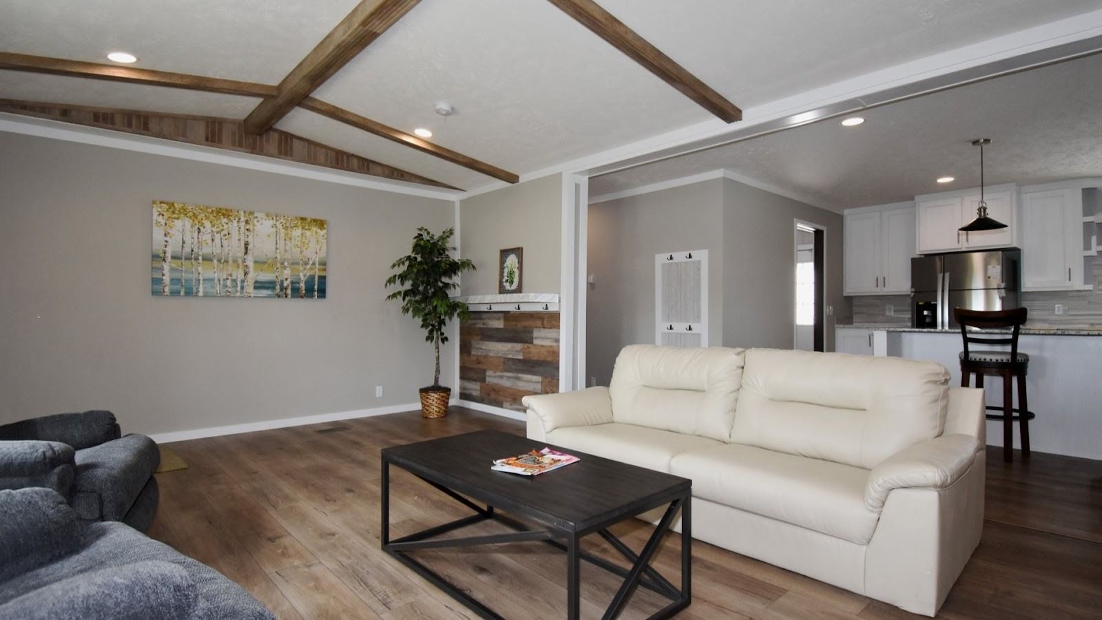 Spacious modern living room with beige leather sofa, dark coffee table with magazines