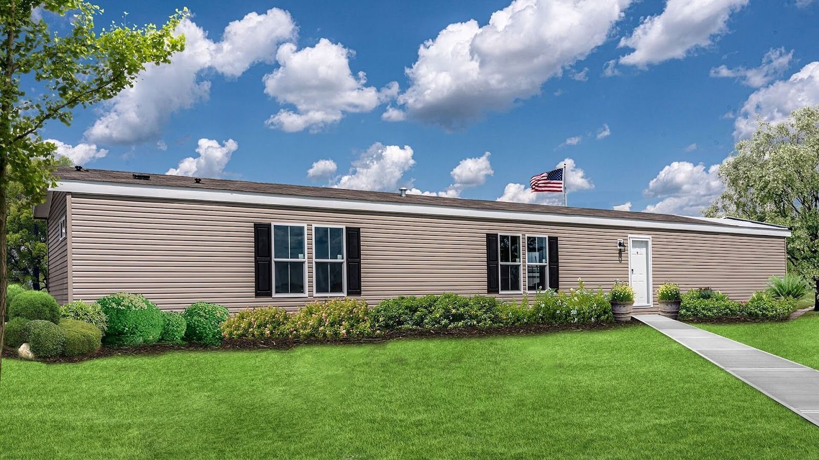 “Single-wide manufactured home with beige siding, landscaped lawn, and walkway leading to the front 