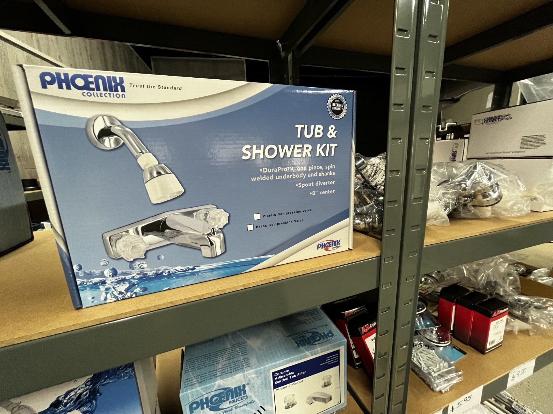 A tub and shower kit is sitting on a shelf in a warehouse.