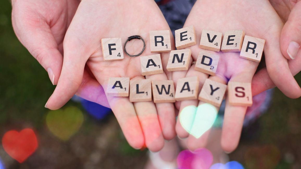 a person is holding scrabble tiles in their hands that say forever and always .