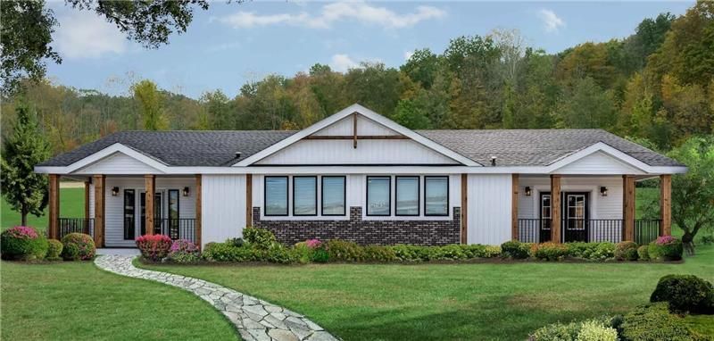 Modern manufactured home with white exterior, brick accents, front porch columns, and landscaped yar