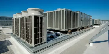 Modern rooftop HVAC units on a large industrial building under a clear blue sky