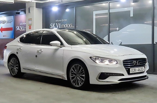 A white car is parked in a parking garage.