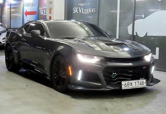 A black sports car is parked in a parking garage.