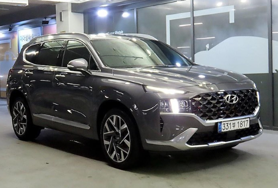 A gray hyundai santa fe is parked in a parking garage.