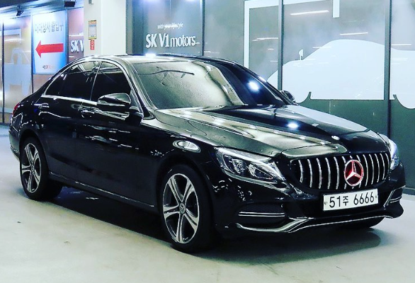 A black mercedes benz is parked in a parking garage.