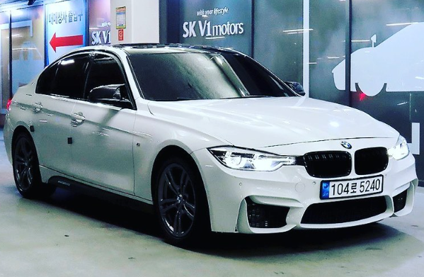 A white bmw m3 is parked in a parking lot.