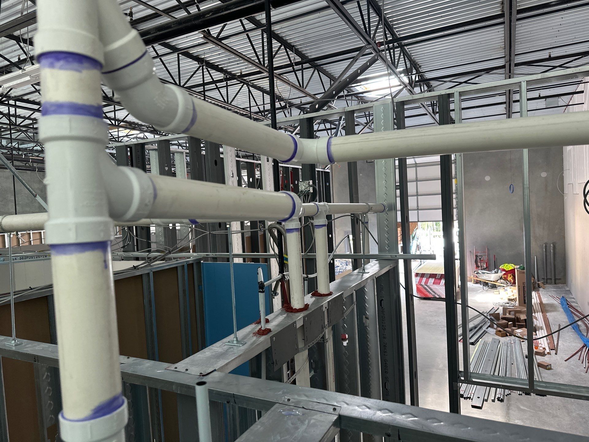 PVC plumbing pipes being installed in a partially constructed building.
