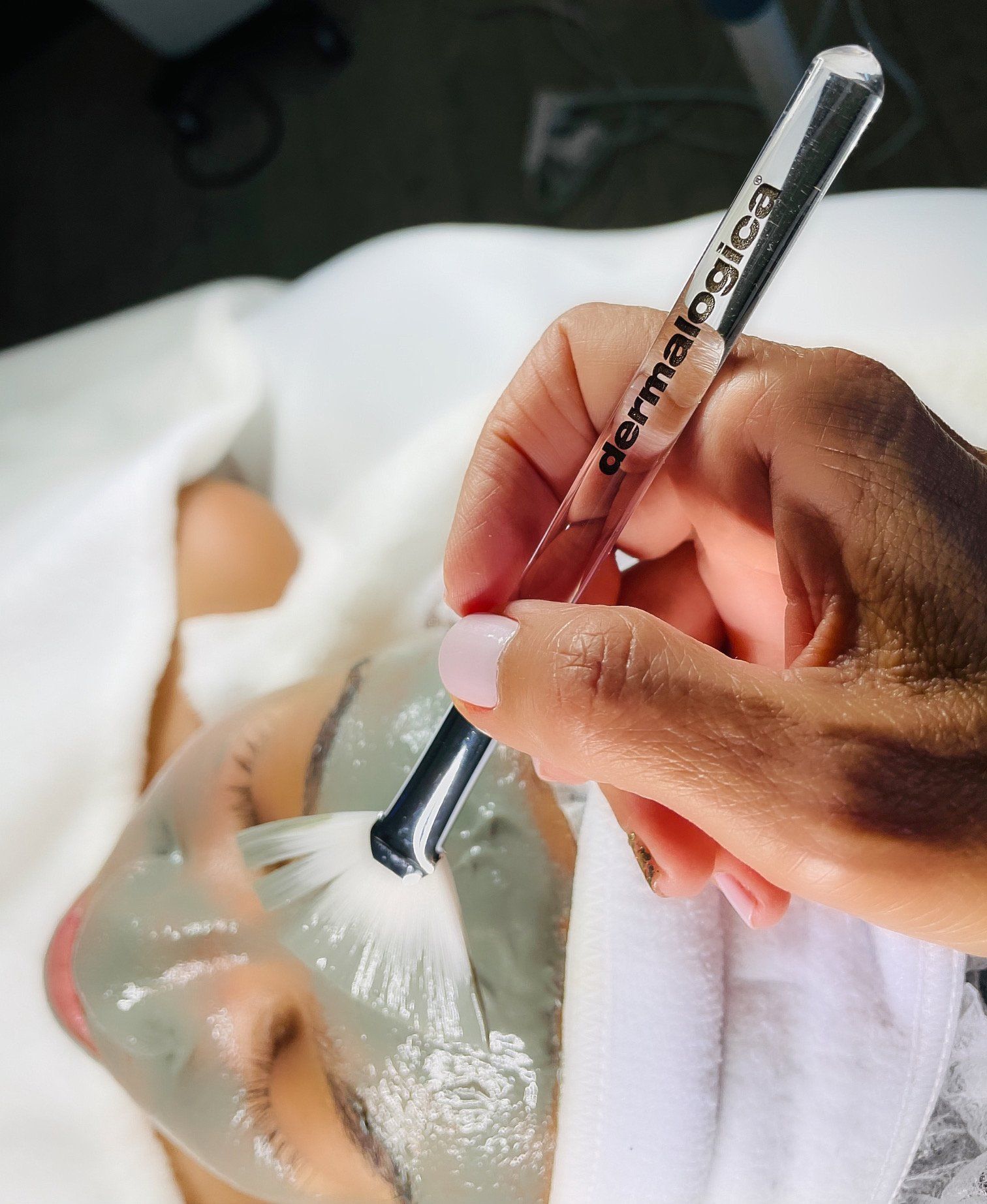 A woman is getting a dermalogica treatment on her face by Rory Lee