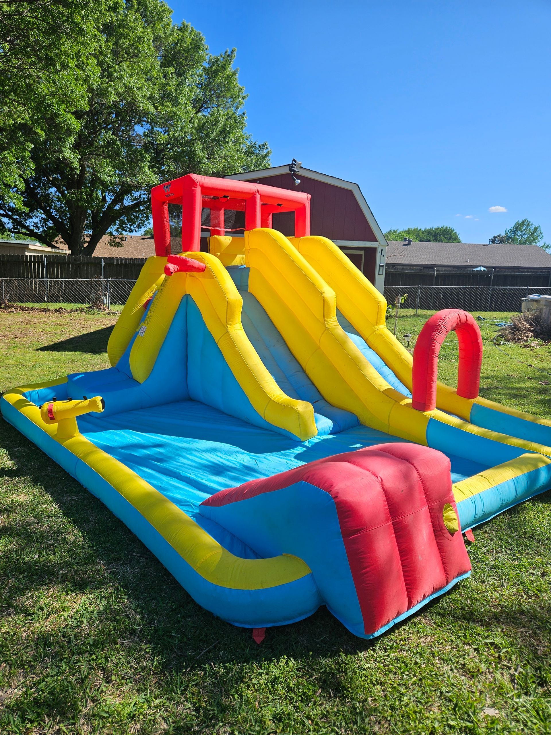 A large inflatable water slide is sitting on top of a lush green field.