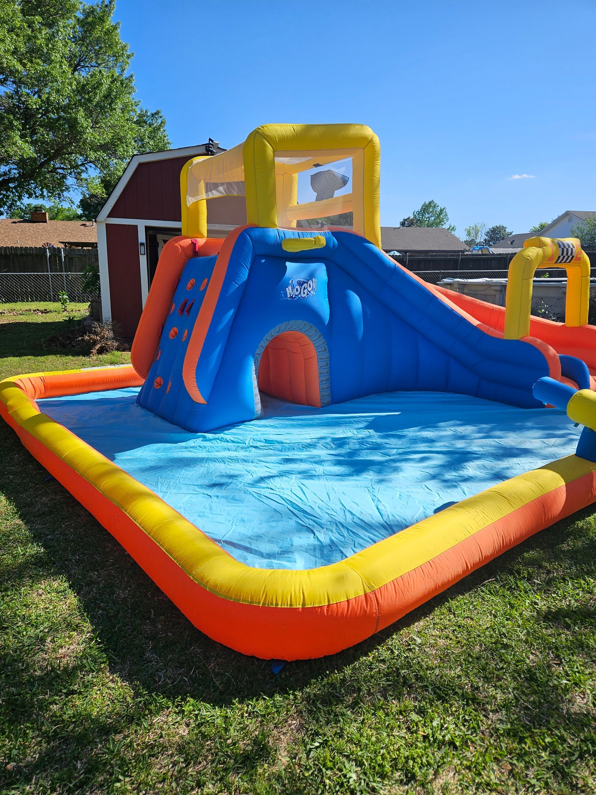 A large inflatable water slide is sitting on top of a lush green field.