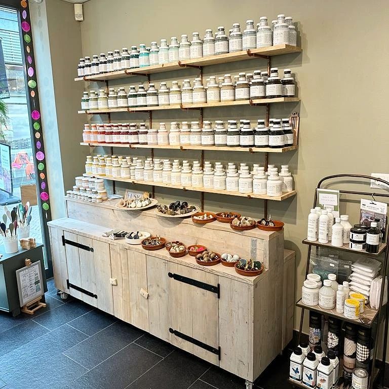 Een winkel vol met veel flessen en planken.