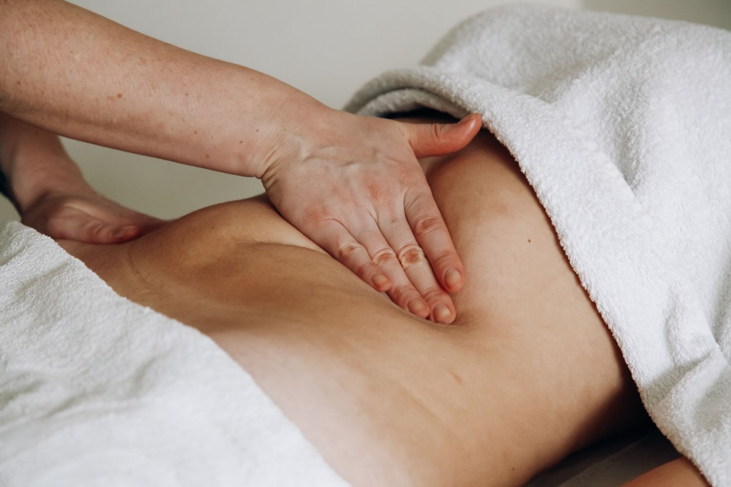 A woman is getting a massage on her stomach in a spa.