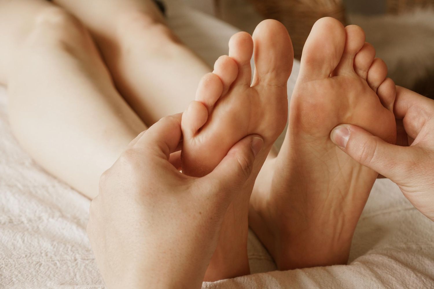 A person is getting a foot massage on a bed.