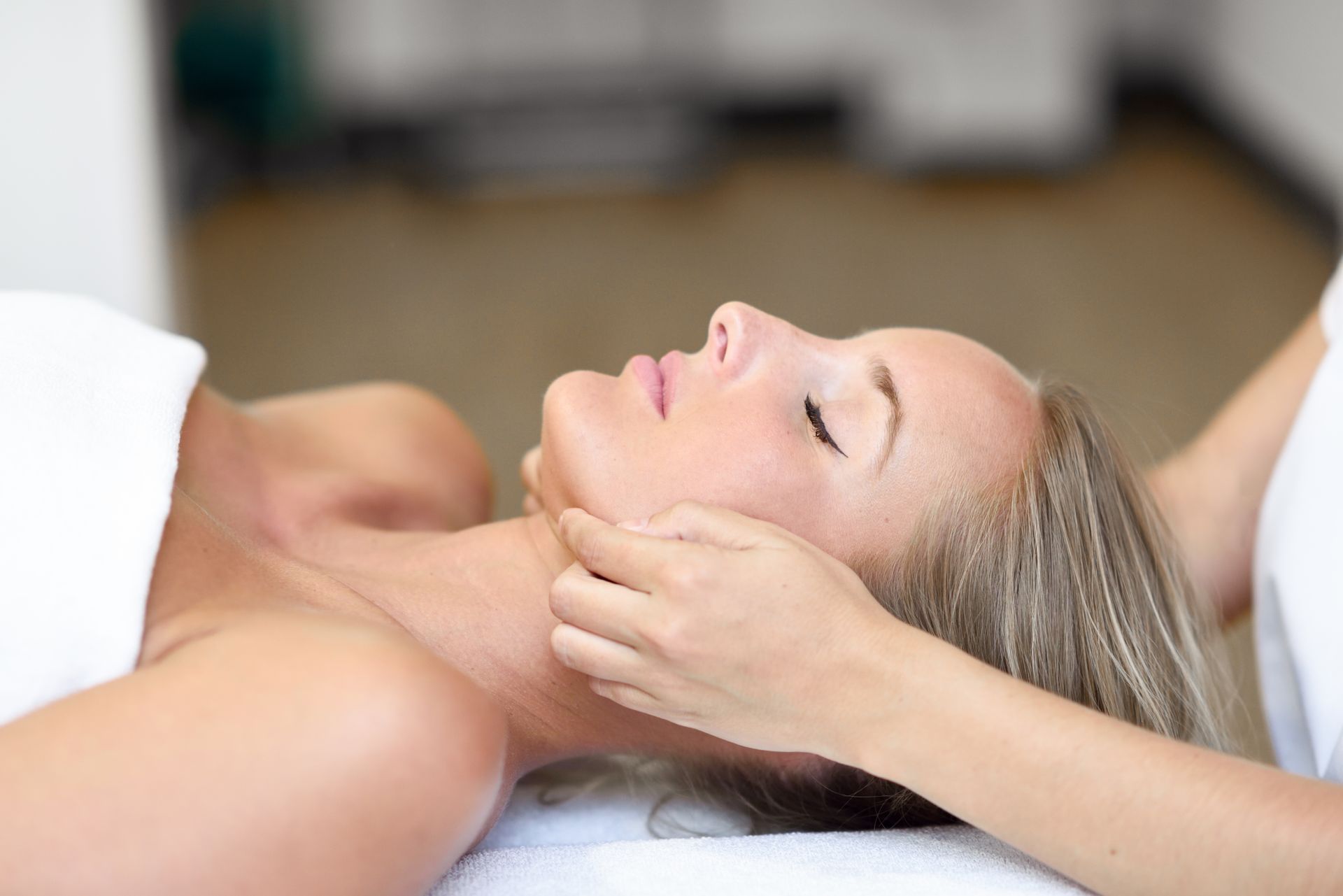 A woman is getting a massage on her face in a spa.