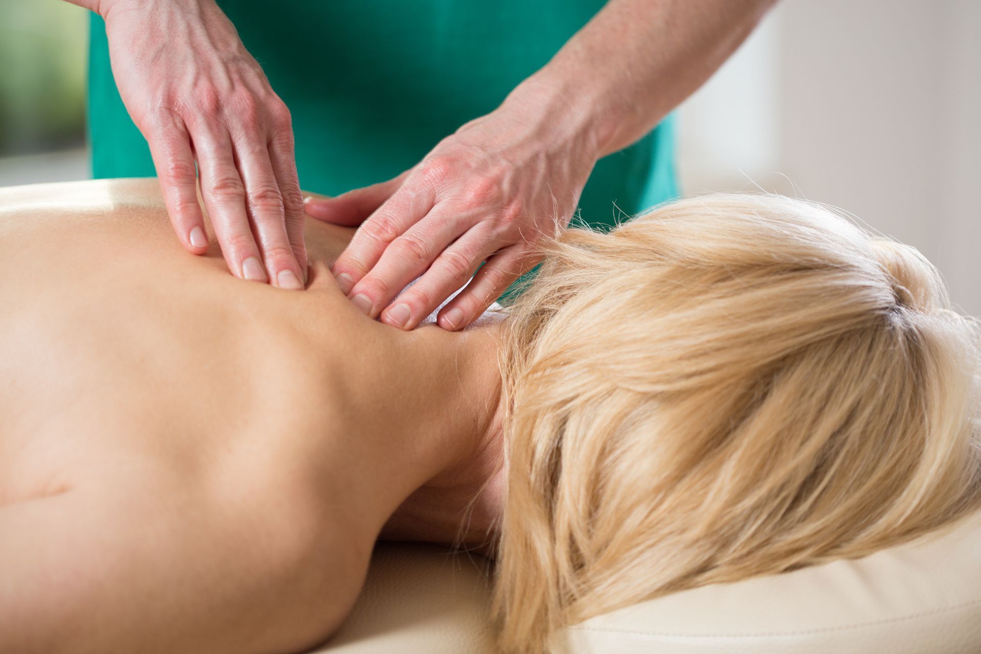 A woman is laying on a table getting a massage from a man.