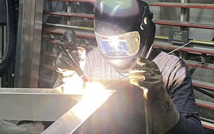 Man in protective clothing welding metal