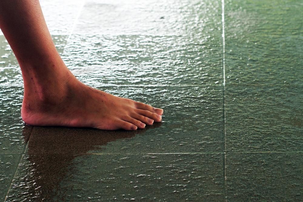 Bare Foot on Wet, Dark Green Tiled Floor — AB QUICK Painting & Maintenance Services In Mareeba, QLD