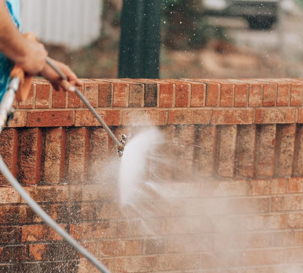 Person Power Washing a Red Brick Wall — AB QUICK Painting & Maintenance Services In Mareeba, QLD