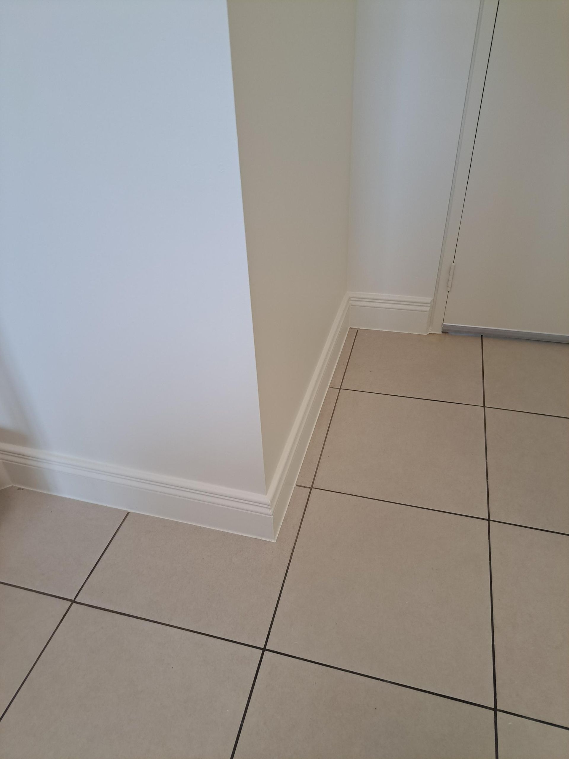 Corner of a Room With White Walls, Tiled Floor, and White Molding — AB QUICK Painting & Maintenance Services In Mareeba, QLD
