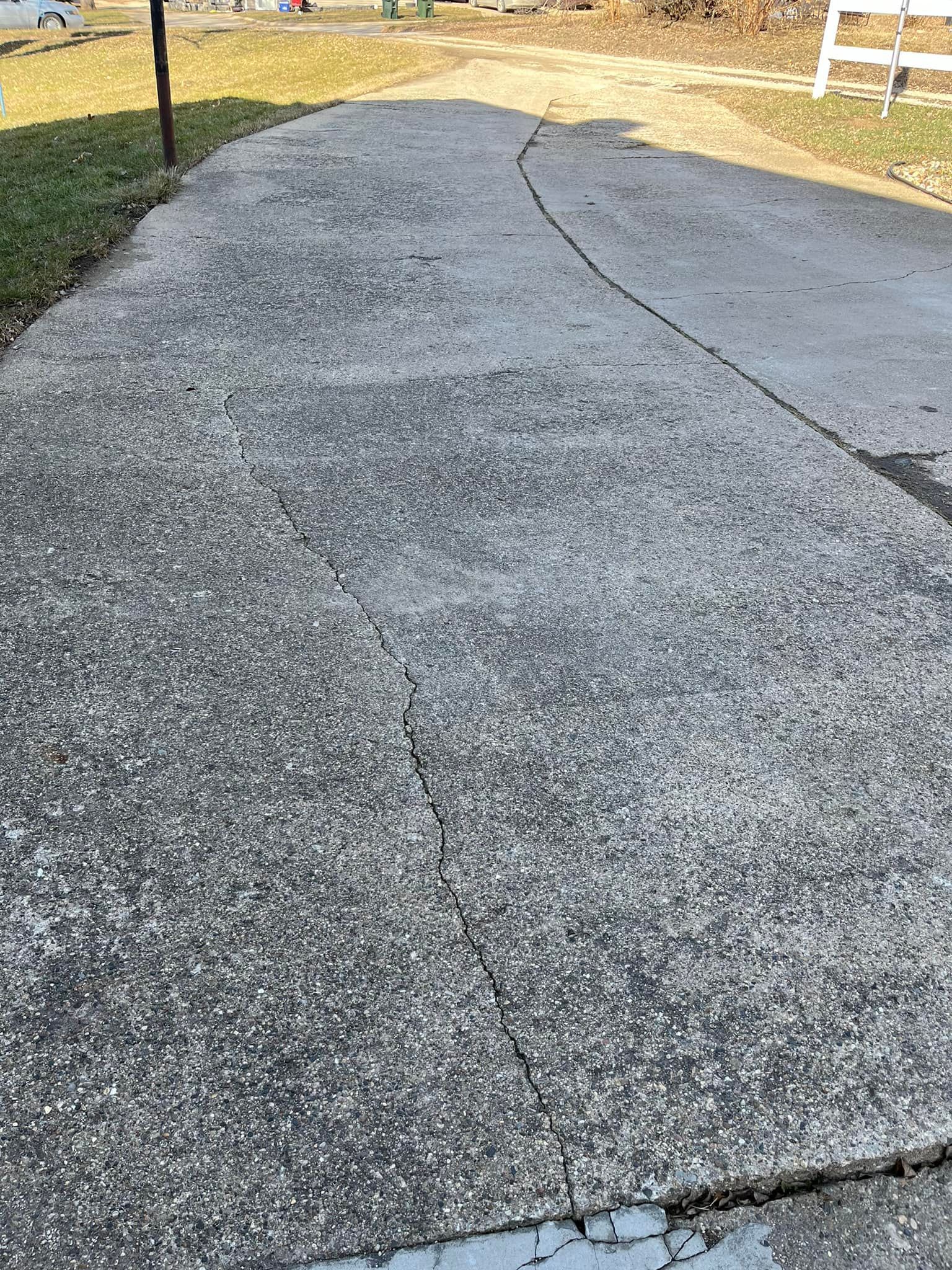 A concrete walkway with a white chair in the background.