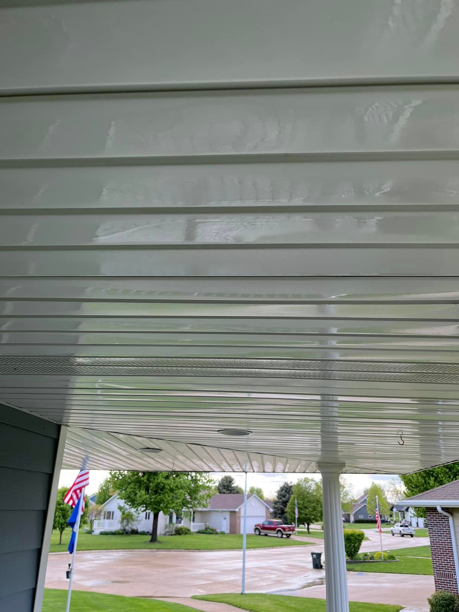 The ceiling of a porch with a view of a residential area.