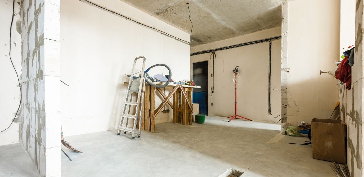 Interior room under construction with tools, wooden supports, and unfinished walls.