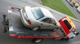 A car is being towed by a tow truck