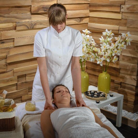 A woman massages the shoulders of a client