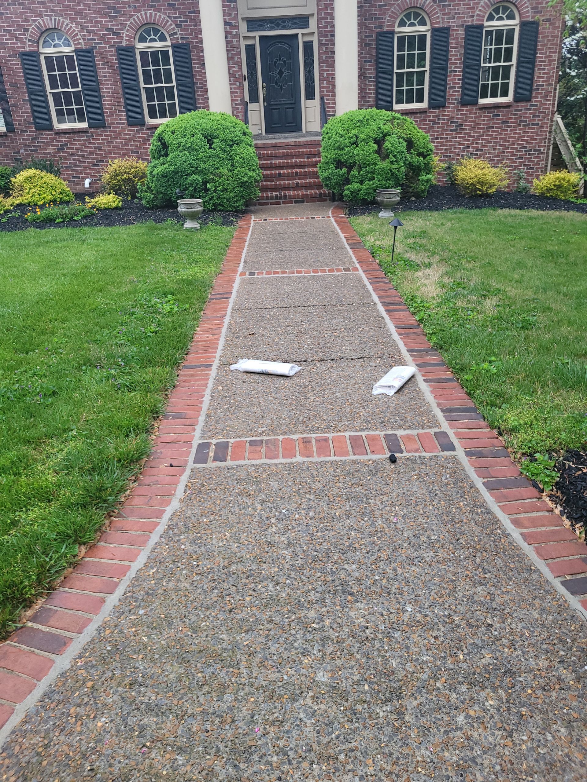 A brick walkway leading to the front door of a house.