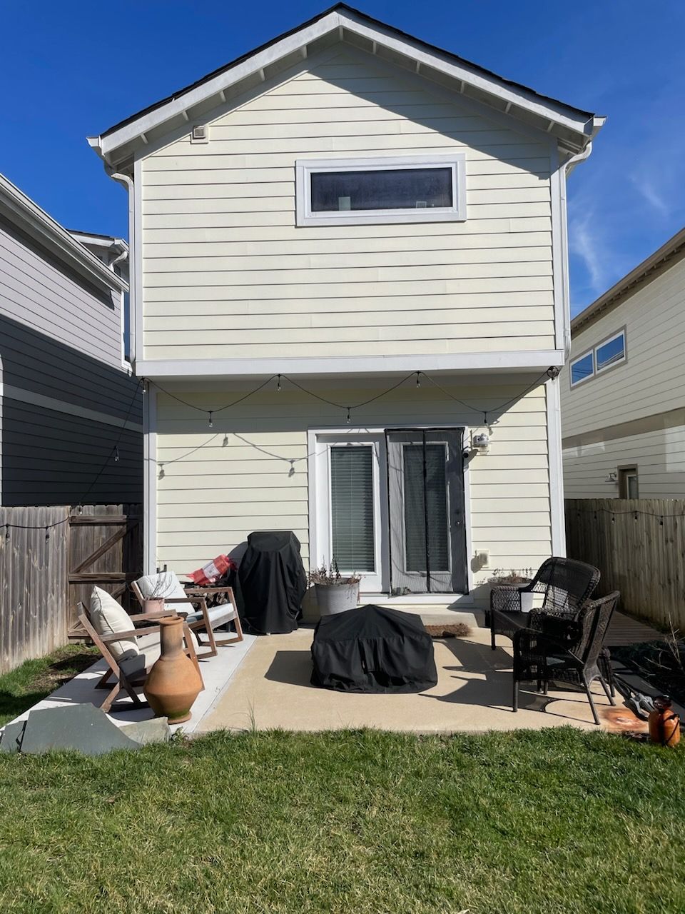 The back of a house with a patio area and a fire pit.