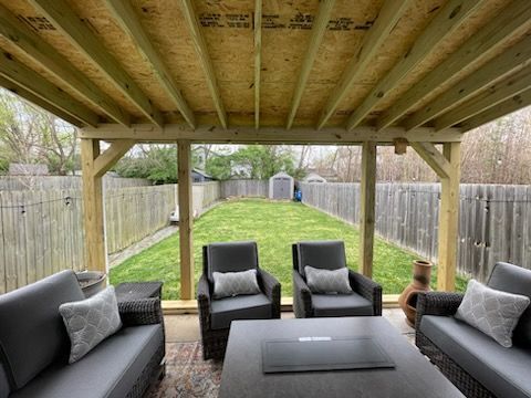 A living room with a couch , chairs , and a table with a laptop on it.