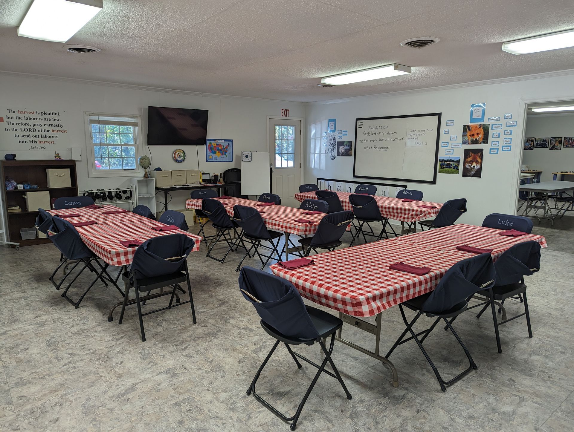 A large room with tables and chairs set up for a party.
