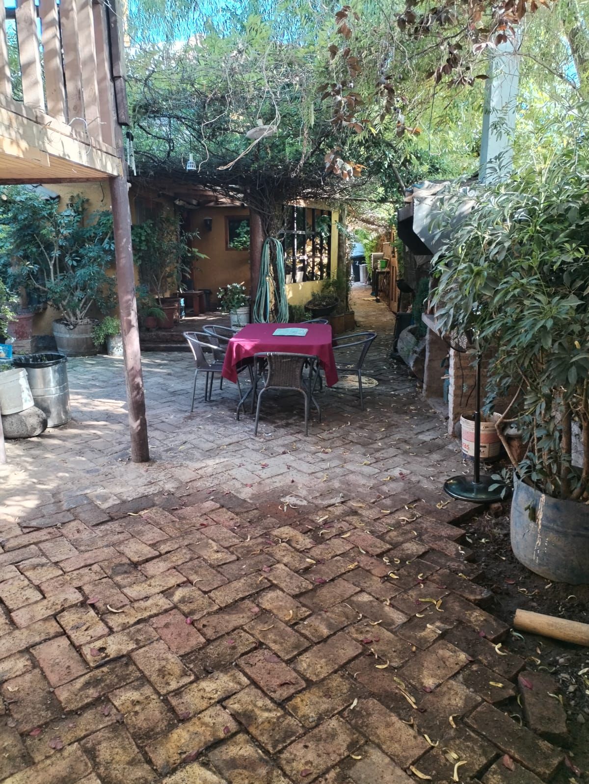 Un patio de ladrillo con una mesa y sillas en el medio.