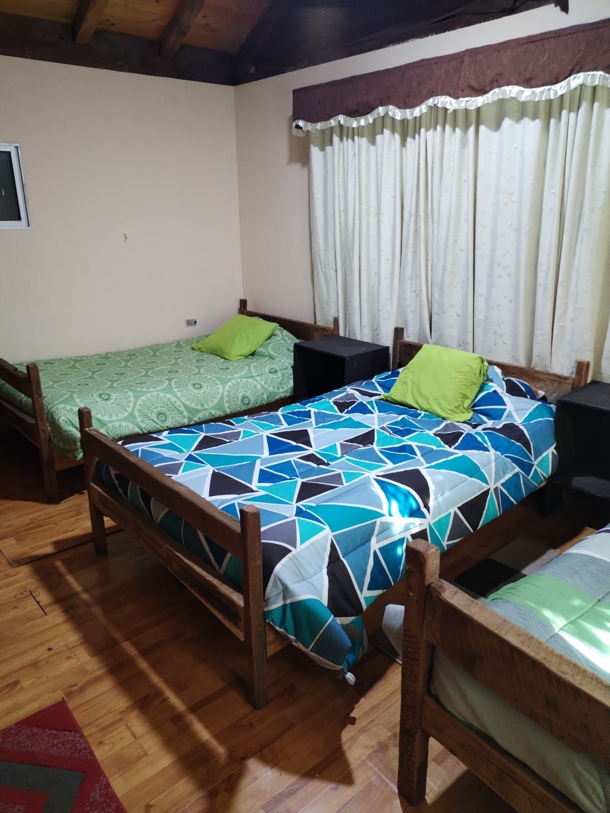 Un dormitorio con dos camas y una ventana con cortinas.