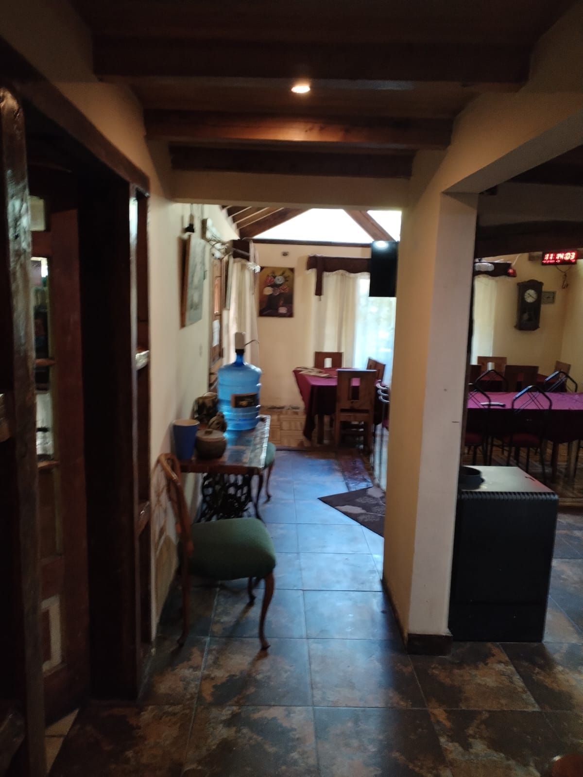 Un pasillo con una mesa y sillas y una mesa de billar.